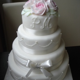 Svatební dort s mašlí a růžemi